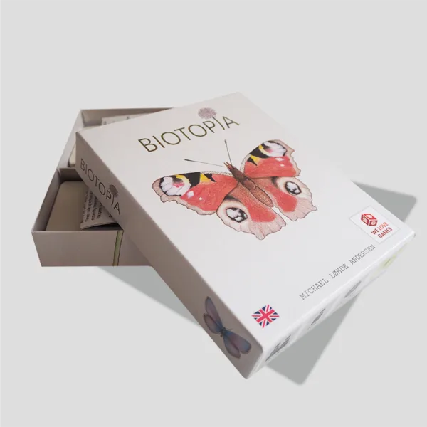 Open box of BIOTOPIA showcasing butterfly cards, mission cards, and player tokens, ready for players to create their gardens and compete for points.