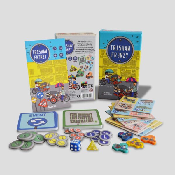 Alle Komponenten von Trishaw Frenzy ausgebreitet (Plättchen, Würfel, Spielsteine, Regelbuch usw.).