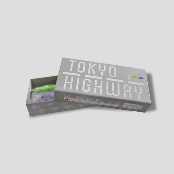 Die geöffnete Tokyo Highway 2 Player Box mit Straßen, Säulen, Autos und Pinzette.